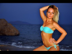 AndainA at nighttime beach in blue bikini